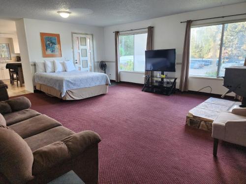 ein Hotelzimmer mit einem Bett und einem TV in der Unterkunft Plainview Motel in Coos Bay