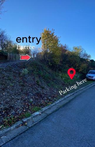 a street sign with the words entryence and parking here at Cabane au style scandinave et son bain nordique in Bouillon