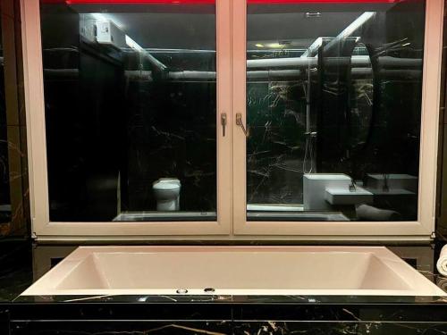 a kitchen with a large window with a sink at La Suite Luxe : Vue Mer - Malo'cation in Dunkerque
