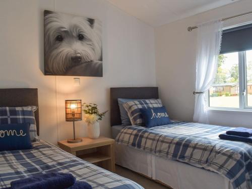 1 dormitorio con 2 camas y una foto de un perro en Devin Lodge en Dollar
