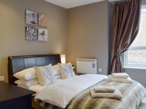- une chambre avec un lit doté de draps et d'oreillers blancs dans l'établissement Gower Sunset Views, à Llanelli