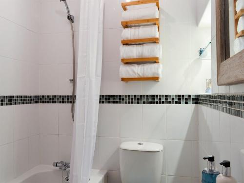 a bathroom with a toilet and a shower and towels at Parsley Cottage in Tideswell