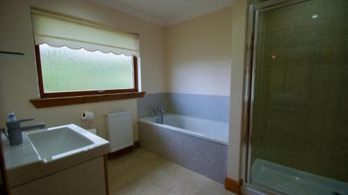 y baño con bañera, lavamanos y ducha. en Allt Beag en Lochearnhead