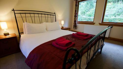 a bedroom with a bed with red towels on it at Allt Beag in Lochearnhead
