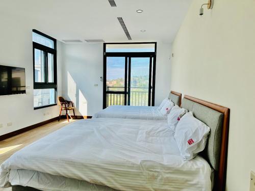 浯島文旅WD Hotel في جينهو: غرفة نوم بسريرين ونافذة كبيرة