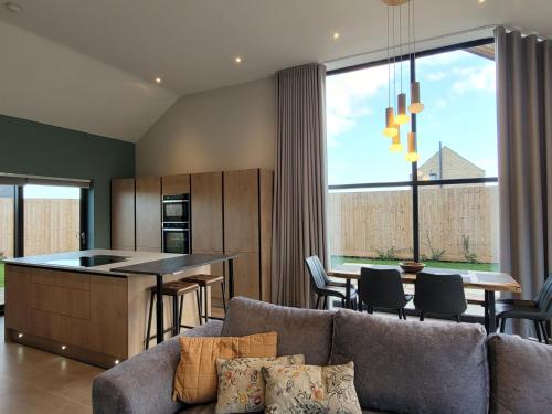 a kitchen and living room with a couch and a table at Castle Hill Barn, Ashlin Farm Barns in Lincoln