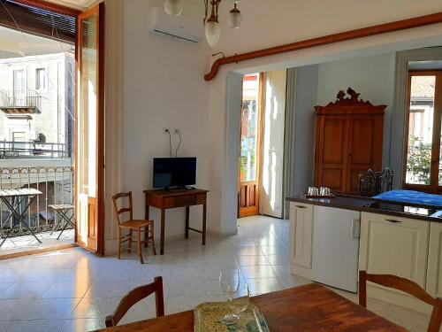 a kitchen and dining room with a table and a television at Bellini Apartment in Catania