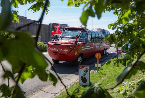 a red bus driving down a street at Gîte à deux pas de l'horloge in Senzeille