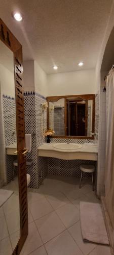 ein Badezimmer mit einer Badewanne, einem Waschbecken und einem Spiegel in der Unterkunft Private Furnished One-Bedroom Apartment at Domina Coral Bay - Block 34 in Sharm El Sheikh