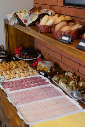a buffet with many different types of pastries on a table at Pousada Cacau in Praia do Rosa