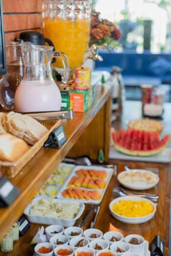 a buffet with many different types of food and drinks at Pousada Cacau in Praia do Rosa