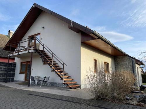a house with a staircase on the side of it at Penzion Klasa - Slezská Harta in Leskovec nad Moravicí
