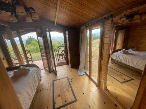 Habitación con 2 camas en una cabaña de madera con ventanas en 7eme ciel - Tiny House avec Grande Piscine intérieure chauffée toute l'année, en Marais-Vernier