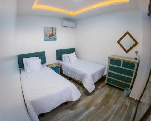 a room with two beds and a dresser in it at Hermosa Casa de Playa Machalilla in Machalilla