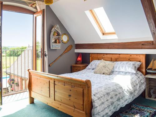 a bedroom with a bed and a balcony at The Milking Barn in Craven Arms