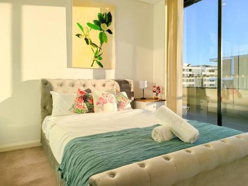 a bedroom with a large bed with a large window at Spacious 3-Bed Penthouse with Perfect View in Sydney