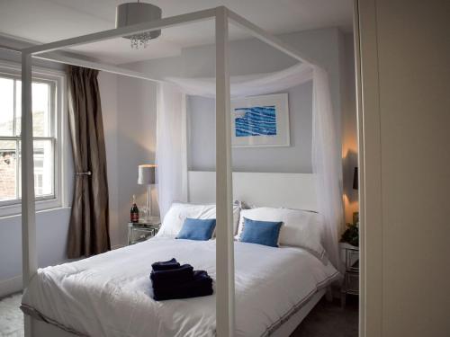 a bedroom with a white bed with a large mirror at Guillemots in Littlehampton