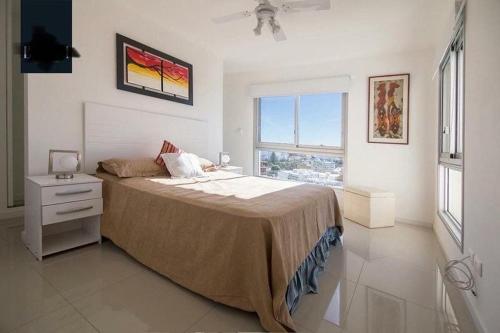 プンタ・デル・エステにあるApartamento Punta del Este,Wind Tower 2 dormitoriosの白いベッドルーム(ベッド1台、窓付)