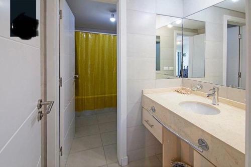 uma casa de banho com um lavatório e um espelho em Apartamento Punta del Este,Wind Tower 2 dormitorios em Punta del Este