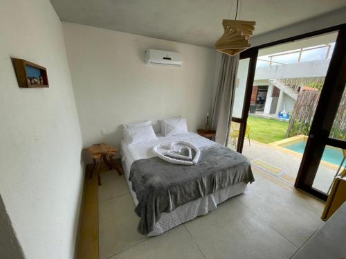 um quarto com uma cama e uma grande janela em Carrapicho Patacho com Piscina Privativa em Porto de Pedras
