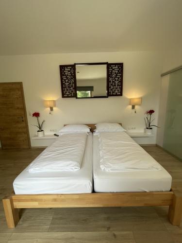 two beds in a room with a mirror on the wall at Sprungschanze Haus in Murau