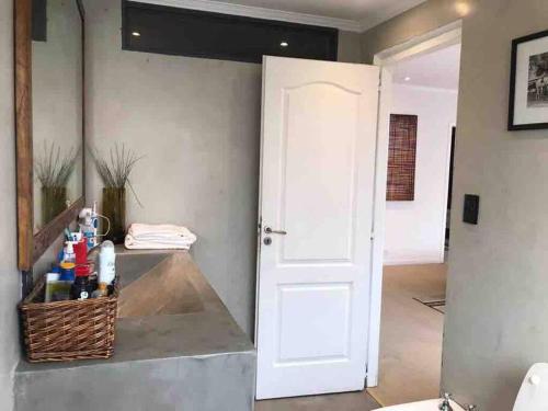 - Baño con puerta blanca y cesta en Casa particular con patio remodelada a nuevo en San Antonio de Areco
