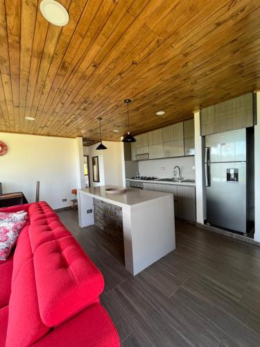 a living room with a red couch and a kitchen at Vaikuntha House in Bruselas