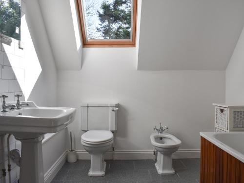 a white bathroom with a sink and a toilet at The Dell in Minehead