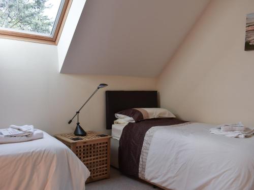 a attic bedroom with two beds and a lamp at The Dell in Minehead