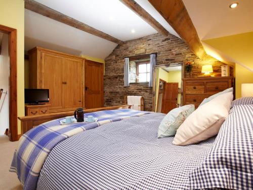 a bedroom with a large bed and a tv at Birch Cottage - Uk4185 in Hazlehead Bridge