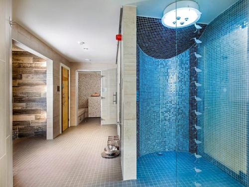 a bathroom with a shower with blue tiles at Birch Cottage - Uk4185 in Hazlehead Bridge