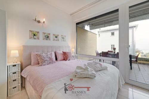 ein Schlafzimmer mit einem großen Bett und einem Balkon in der Unterkunft 'Cuore di Rose' Parking - Welcome Set, Netflix, for 4 Persons -By EasyLife Swiss in Breganzona