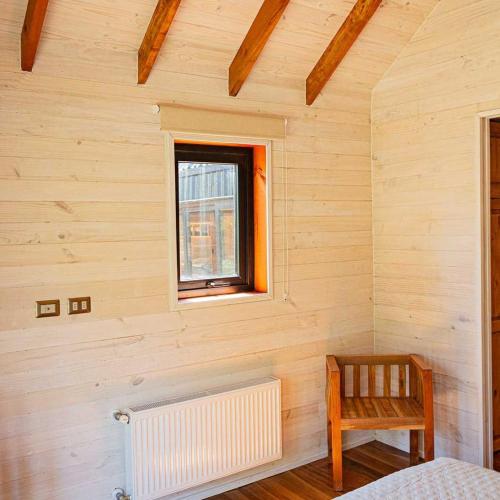 a room with a window and a radiator and a chair at Los Cantos del Agua in Malalcahuello
