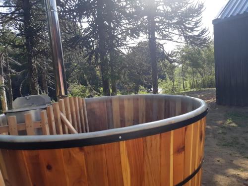 a wooden tub with a wooden fence in a yard at Los Cantos del Agua in Malalcahuello