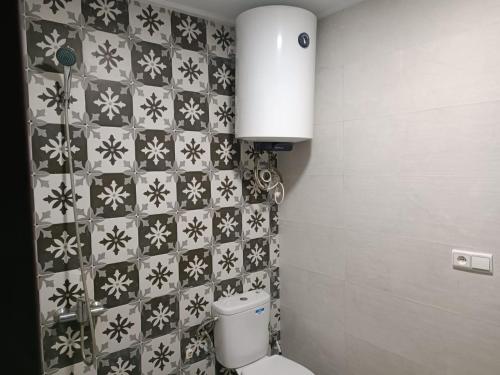 a bathroom with a toilet and a tiled wall at place to be saidia in Saïdia