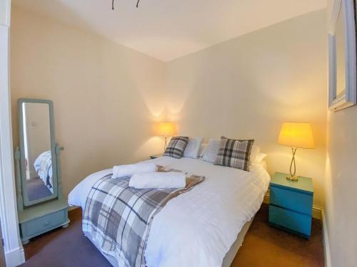 a bedroom with a bed with a mirror and a lamp at Largs Brisbane Cottage in Largs