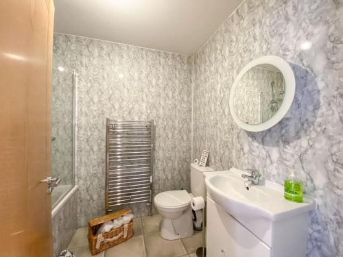 a bathroom with a sink and a toilet and a mirror at Largs Brisbane Cottage in Largs