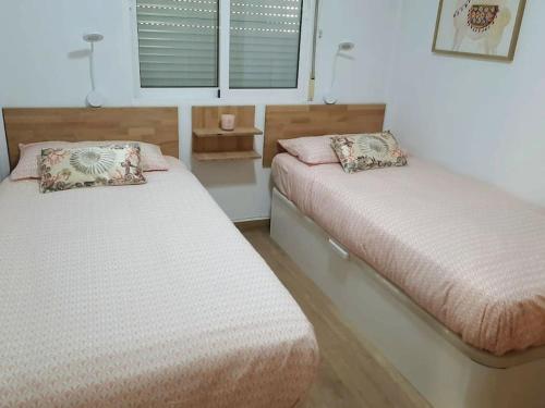 a bedroom with two beds and a window at Duplex Flamenca Beach La Zenia Boulevard in Orihuela Costa
