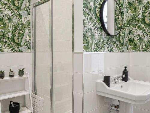 een badkamer met een douche, een wastafel en een spiegel bij Dezzys in Montrose
