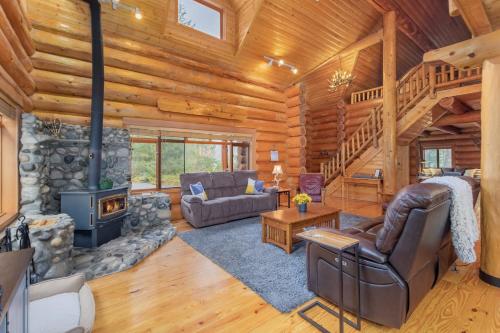 a living room with a fireplace in a log cabin at Soaring Pines Lodge by NW Comfy Cabins in Leavenworth