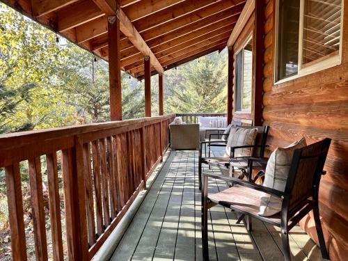a porch of a cabin with chairs on it at Raven Haven Lodge by NW Comfy Cabins in Leavenworth