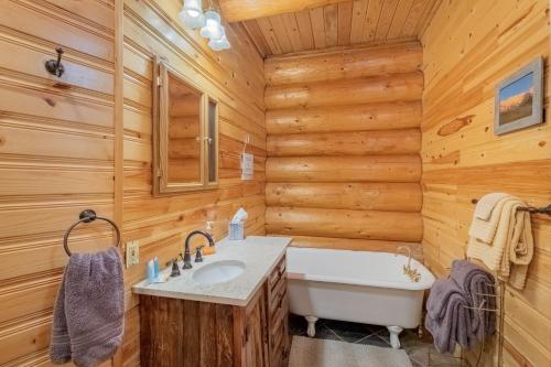 a log cabin bathroom with a tub and a sink at Soaring Pines Lodge by NW Comfy Cabins in Leavenworth