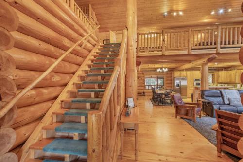 a staircase in a log cabin with a living room at Soaring Pines Lodge by NW Comfy Cabins in Leavenworth