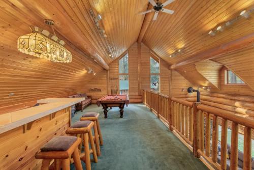 a large room with a pool table and wooden walls at Soaring Pines Lodge by NW Comfy Cabins in Leavenworth
