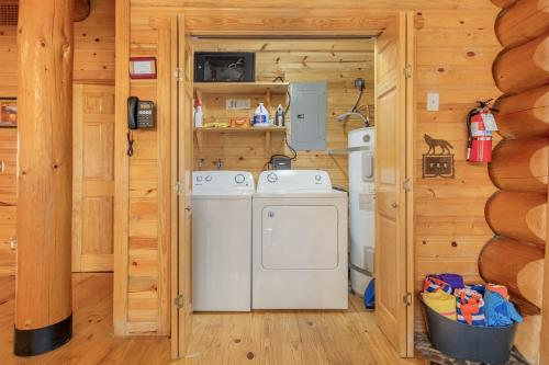 a laundry room with a washer and dryer in a log cabin at Soaring Pines Lodge by NW Comfy Cabins in Leavenworth