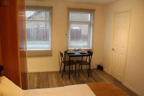 1 dormitorio con mesa, sillas y 1 cama en Modern studio apartment with parking en Chatham