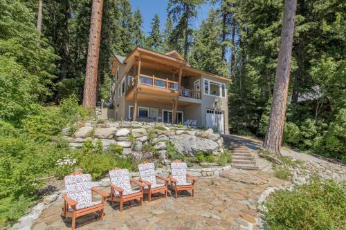 a house in the woods with chairs and trees at Lazy Bear Lodge by NW Comfy Cabins in Leavenworth
