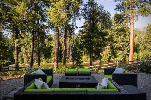 a patio with a green couch and a table at Riffle River Lodge by NW Comfy Cabins in Leavenworth