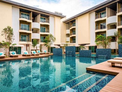 a swimming pool in front of a hotel at Mercure Langkawi Pantai Cenang in Pantai Cenang