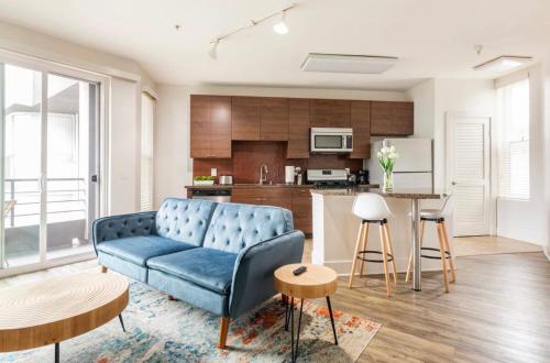 a living room with a blue couch and a kitchen at Tulum Vibes 1 Bedroom Apartment near Boats in Marina Del Rey in Los Angeles